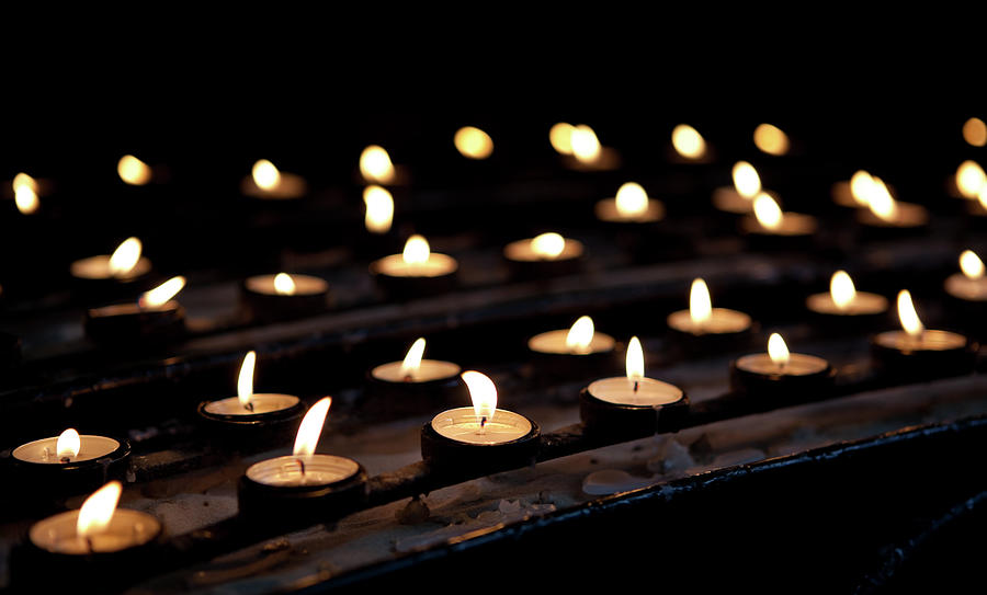 Votive prayer candles glowing in the dark